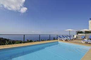 - une piscine avec des chaises et une vue sur l'océan dans l'établissement Casa Vista do Ledo, à Arco da Calheta