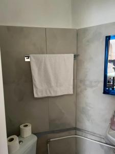 a bathroom with a towel hanging above a toilet at Mandarine hostel in Tirana +67 photos
