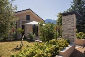 a house with an umbrella in a garden at Casa Vacanze Al Cielo 2 in Sarnano