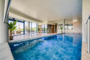 a swimming pool with blue water in a house at Bois d'Arlon Hotel & SPA in Arlon