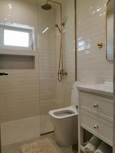 a bathroom with a toilet and a glass shower at Casa Olive Costinești in Costinesti