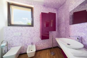 a purple bathroom with a sink and a mirror at Casa Vacanze Al Cielo 2 in Sarnano +16 photos