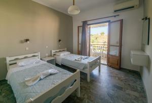 two beds in a room with a balcony at Newquay beach club in Kavos