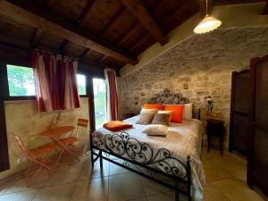 a bedroom with a bed with orange pillows on it at La Cascina della Vachina in Poggio Bustone