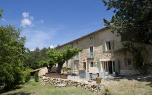 a stone house with a table and chairs in a yard at La bastide d'emilie sud est in Saint Antonin du Var