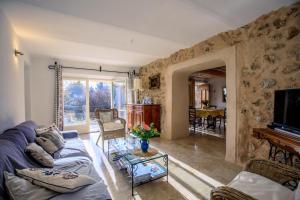 a living room with a blue couch and a piano at La bastide d'emilie sud est in Saint Antonin du Var