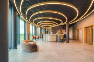 a lobby with a couch and a bar in a building at Bois d'Arlon Hotel & SPA in Arlon +73 photos