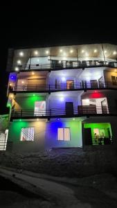 a lit up building with green and blue lights at Trishool inn residency in Chandrāpuri