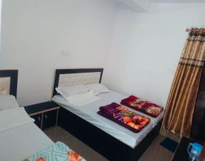 a small bedroom with two beds in a room at Trishool inn residency in Chandrāpuri +9 photos