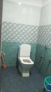 a bathroom with a toilet and a green and white wall at Trishool inn residency in Chandrāpuri