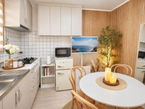 a white kitchen with a table and chairs at 수원 화서역 편한 집 in Suwon