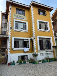 a yellow building with a sign on it at Golden Mud in Srinagar +13 photos