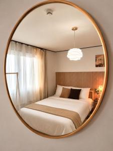 a bedroom with a bed in a round mirror at 수원 화서역 편한 집 in Suwon