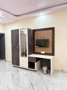 a living room with a tv on a wall at Hotel Food Avenue in Jāmb +12 photos