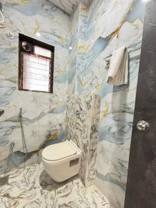 a bathroom with a white toilet and a window at Hotel Food Avenue in Jāmb