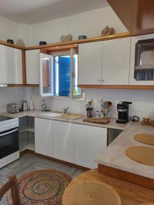 a kitchen with white cabinets and a counter top at Manolia Home in Parikia