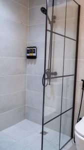 eine Dusche mit Glastür im Badezimmer in der Unterkunft Kadiss Hotel in Dakar