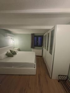 a bedroom with a large white bed and wooden floors at La Casa di Mimma in Badolato