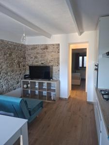 a living room with a blue couch and a stone wall at La Casa di Mimma in Badolato