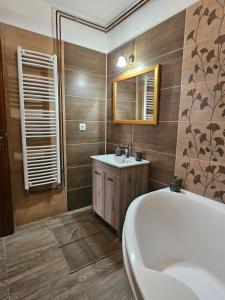 a bathroom with a tub and a sink at Kapolcsi Kuckó in Kapolcs