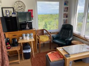 a living room with a tv and a chair at Jacquie's B&B -Dumfries-Room with a view in Dumfries