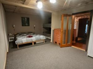 a bedroom with a bed and an open door at Melleņu ligzda in Puršēni