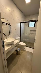 a bathroom with a sink and a toilet and a shower at Pousada raios de sol in Chapada dos Guimarães +54 photos