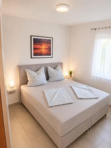 a bedroom with a large white bed with two pillows at Apartments Adria in Vir