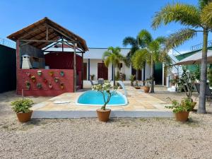 a swimming pool in a yard with palm trees at Lounge Pdd - Espaço inteiro in Aquiraz