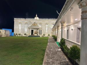 a large white building at night with a grass yard at Hotel SR Vivanta,Brahmapur in Brahmapur