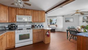 a kitchen with wooden cabinets and a white stove top oven at Cape Bay Cottage in North Cape May +24 photos
