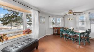 a dining room with a table and chairs and a couch at Cape Bay Cottage in North Cape May