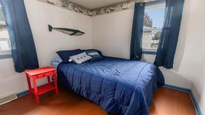 a small bedroom with a bed and a red table at Cape Bay Cottage in North Cape May