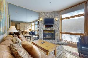 a living room with a couch and a fireplace at River Bank Lodge 2919 in Keystone