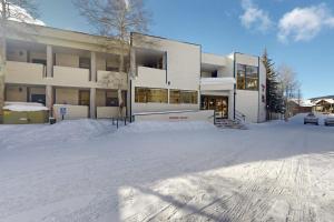 a snow covered parking lot in front of a building at River Bank Lodge 2919 in Keystone