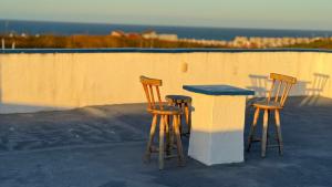 two chairs and a table on a patio with the ocean at Lounge Pdd - Espaço inteiro in Aquiraz