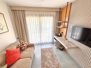 ein Wohnzimmer mit Sofa und Fernseher in der Unterkunft WeSuites in Fethiye