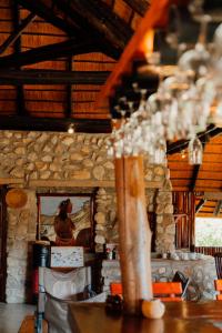 a room with a table and a stone wall at Kapika Waterfall Lodge in Epupa