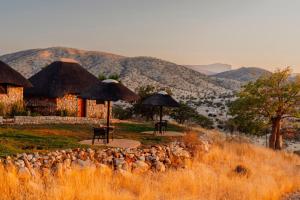 a herd of sheep standing in front of a building at Kapika Waterfall Lodge in Epupa +58 photos