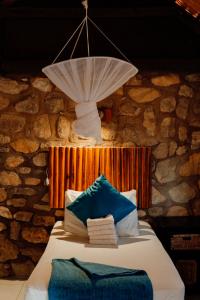 a room with a bed with a chandelier above it at Kapika Waterfall Lodge in Epupa