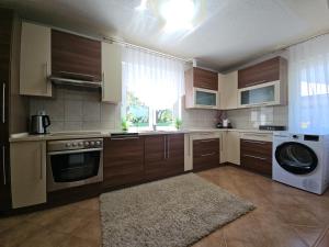 a kitchen with wooden cabinets and a washer and dryer at Villa Aylin in Bihać
