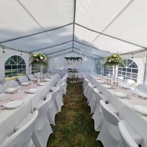 a marquee with white tables and chairs and flowers at "Grzesiówka" in Czarnożyły