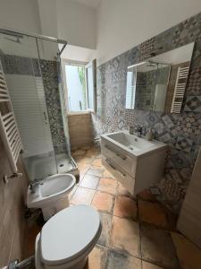 a bathroom with a toilet and a sink and a shower at Bouganville House in Nettuno +17 photos