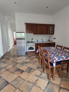 a kitchen with a table with chairs and a refrigerator at Bouganville House in Nettuno
