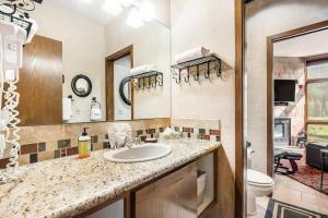 a bathroom with a sink and a toilet and a mirror at 2914 River Bank Lodge - Keystone in Keystone +49 photos