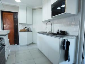a white kitchen with a sink and a counter at Oliverio Seaside Living in Sedgefield