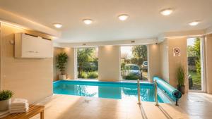 a swimming pool in a room with a swimming pool at AH-Corso Wellness Apartment in Siófok