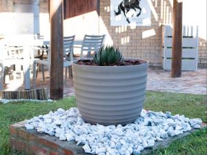 a large white pot sitting on a pile of rocks at Oliverio Seaside Living in Sedgefield