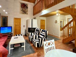 a living room with a couch and chairs and a tv at Par 10 in Tahkovuori