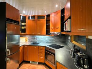 a kitchen with wooden cabinets and stainless steel appliances at Par 10 in Tahkovuori +9 photos
